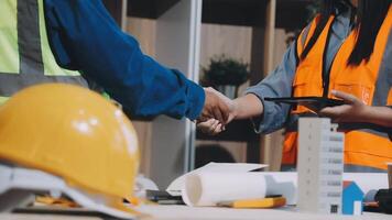 Two construction workers shaking hands while working on a project video