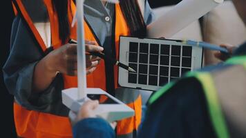 Two people in safety vests holding a solar panel video
