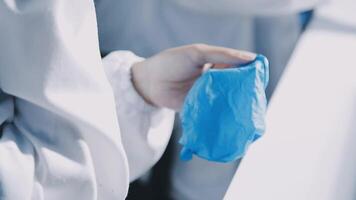 A person in a lab coat holding a blue bag video