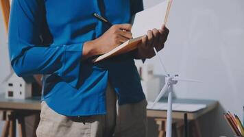 A man is writing on a notebook while holding a pen video