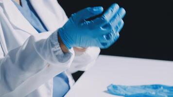 A person in a lab coat is wearing blue gloves video