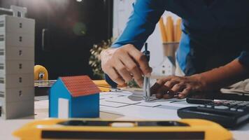 uma pessoa é trabalhando em uma projeto com uma calculadora e uma casa video
