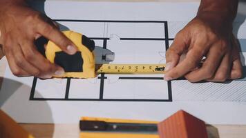 A person is using a measuring tape to measure a house video