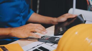 A person using a calculator and a hard hat video