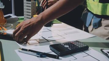 A man is working on a project with a calculator and other tools video