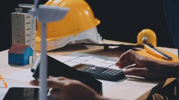 A person is using a calculator and a hardhat video