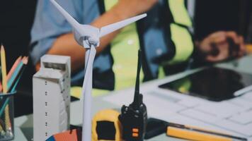 A person working on a laptop with a wind turbine video