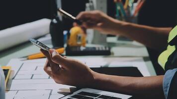 en person är använder sig av en cell telefon medan arbetssätt på en projekt video