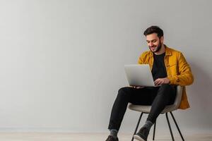 Man in yellow jacket enjoys working on laptop photo