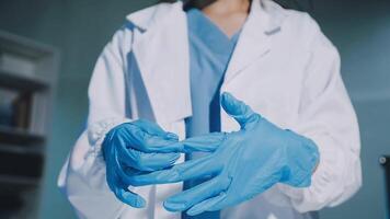 A woman in a lab coat is holding a pair of blue gloves video