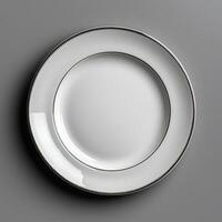 Elegant white ceramic plate with blank center and decorative rim photo