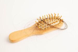 Hair loss fall with comb brush isolated on white photo