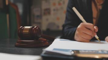 A judge's gavel is sitting on a desk with a pen and paper video