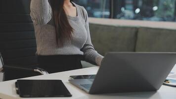 A woman sitting at a desk with her hands up video
