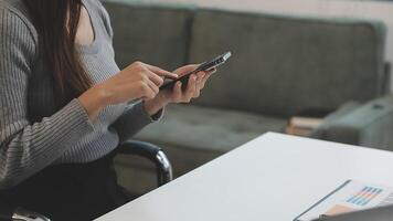 A woman using her phone while sitting at a desk video