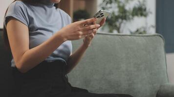 A woman sitting on a couch using her phone video