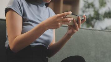A woman sitting on a couch using her phone video