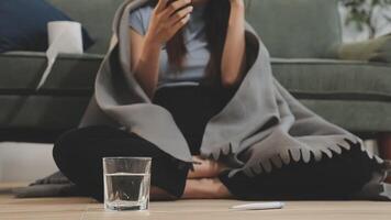 A woman sitting on the floor with a blanket and a glass of water video
