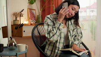 Multitasking Asian Korean woman talking mobile phone call cellphone writing notes entrepreneur worker busy female girl businesswoman at home overload deadline office business indoor notebook stress video
