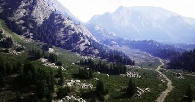 Scenic mountain landscape with winding path and lush greenery during daylight video