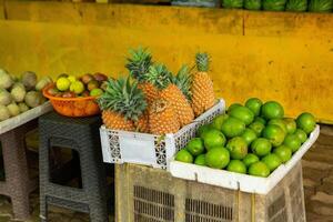 A basket filled with an assortment of tropical fruits like guava, soursop, and rambutan at a vibrant Sri Lankan market. photo