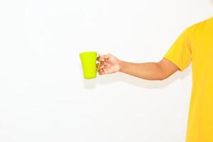 Bright yellow shirted person holds a green mug on a clear white background photo