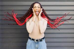 An Excited Woman with Striking Red Braids Expressing Pure Joy Against a Stylish Background photo
