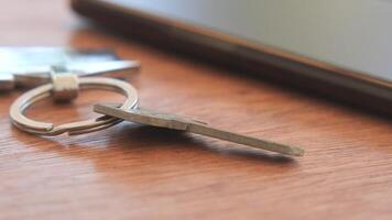 Key and smartphone placed on wooden table in a casual setting video