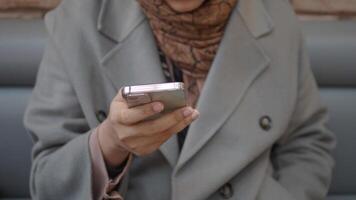 Individual engaged with smartphone while seated in a cozy cafe video