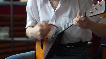 Girl playing on Russian balalaika at home, closeup view on hands and strings video