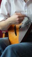 Girl play the Russian balalaika quickly and energetically at home, closeup view on hands and strings video
