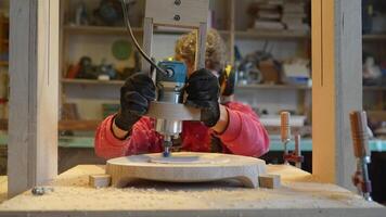 Carpentry workshop craftsman master working. Man with woodworking machine. Sawdust flies into camera video