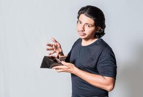 Young man with financial crisis holding wallet isolated. Sad man holding empty wallet. Unhappy man with financial crisis isolated photo