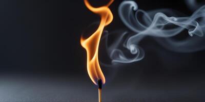 Bright flame dancing on a matchstick with wisps of smoke rising in a dark background. photo
