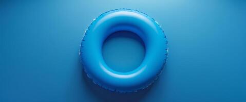 Bright blue inflatable pool ring resting on a solid blue background in a serene and calm setting photo