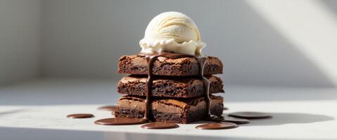 A decadent brownie stack topped with melted chocolate and a scoop of vanilla ice cream on top photo