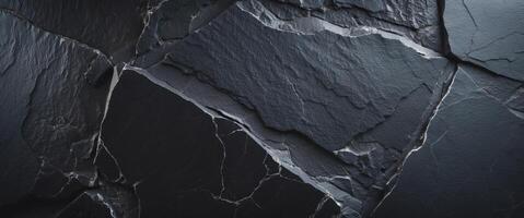 Black slate rock background texture with a rough and uneven surface creating a dark and moody backdrop photo