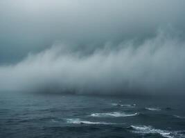Fog rolling over a deep blue ocean water surface creating a mystical and moody atmosphere photo