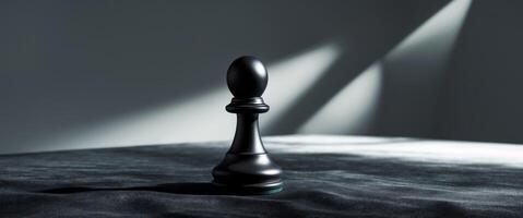 Black chess pawn positioned on a dark surface with intriguing lighting effects photo