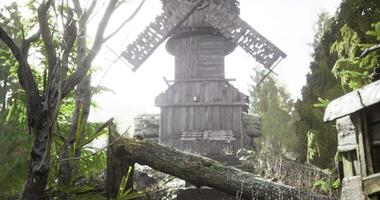 Old windmill surrounded by trees in a sunlit forest setting video