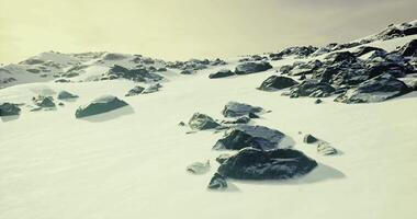 Winter snowy rocky terrain under a cloudy sky in a remote area video