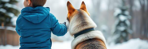 Child and dog enjoy a snowy walk in a serene winter landscape surrounded by trees photo