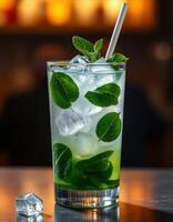 Refreshing mint beverage served in a tall glass filled with ice and green leaves photo