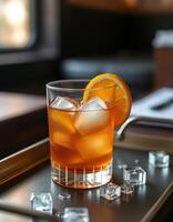 Refreshing cocktail served on a tray with ice and orange slice in a cozy bar during the late afternoon photo