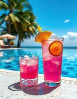 Bright tropical drinks by the pool in a sunny resort setting under a clear sky photo
