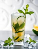 Refreshing mojito with fresh mint and lime on a bright surface with ice cubes and lemon slice in the background photo