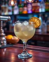 Refreshing cocktail served with ice and lemon slice at a vibrant bar during the evening hours photo