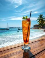 Refreshing summer beverage on the beach with clear blue skies and gentle waves in the background photo