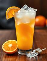 Refreshing orange drink served in a tall glass with ice and garnished with a slice of orange photo