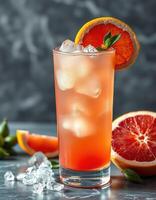 Refreshing citrus drink served in a tall glass with ice and garnished with orange slice and mint leaves photo